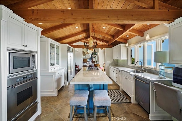 kitchen featuring sink, a kitchen island, white cabinets, and appliances with stainless steel finishes