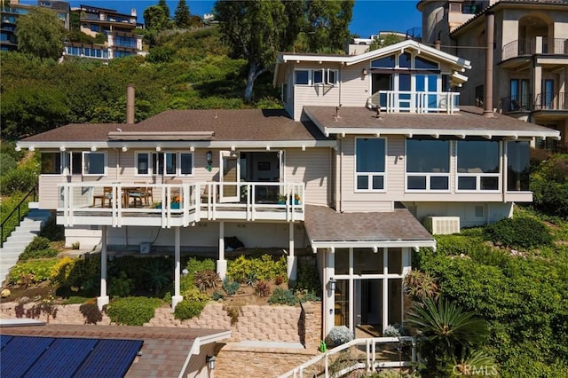 back of house with a balcony, central AC unit, and a patio area