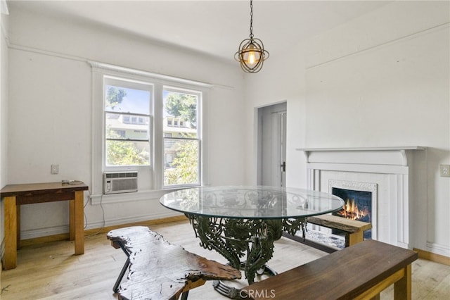 dining space with cooling unit and light wood-type flooring