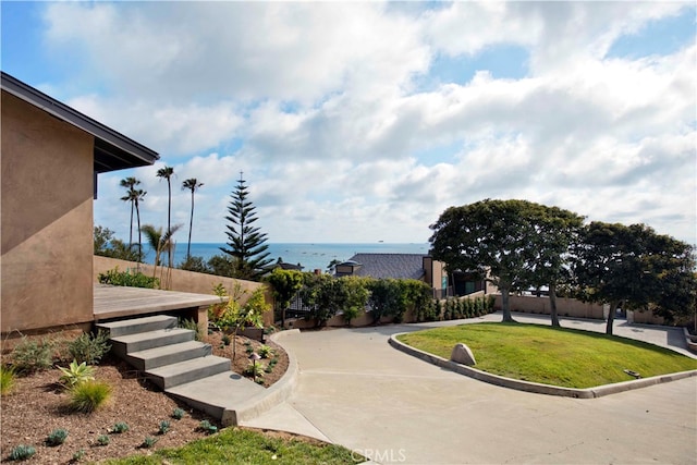 view of home's community featuring a water view and a yard