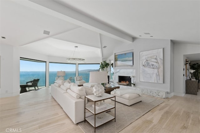 living room with vaulted ceiling with beams, light hardwood / wood-style floors, a high end fireplace, and a water view