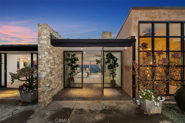 exterior entry at dusk with a patio