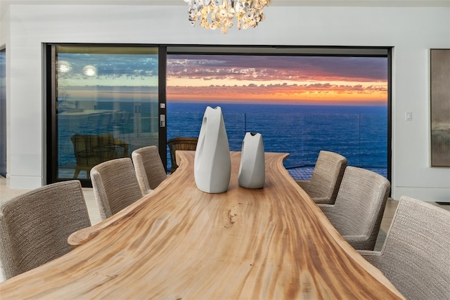 dining space with a notable chandelier and a water view