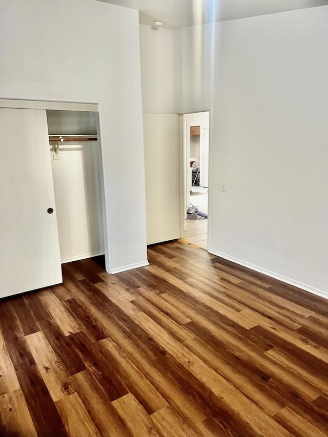 unfurnished bedroom with a closet and dark wood-type flooring