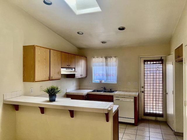 kitchen with a kitchen breakfast bar, white dishwasher, vaulted ceiling, sink, and tile countertops