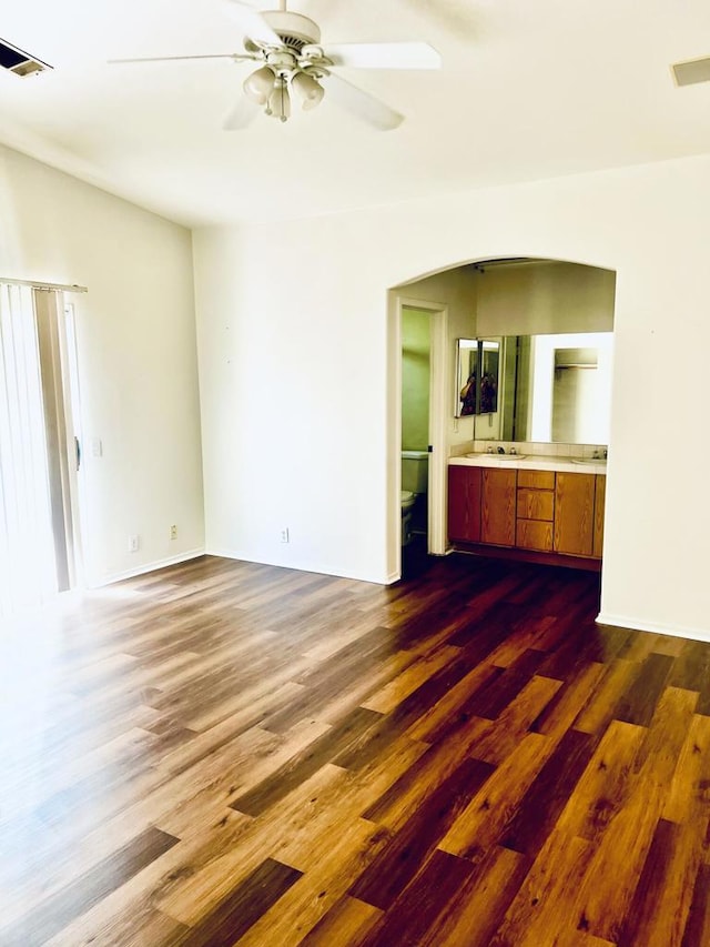 unfurnished living room featuring ceiling fan and dark hardwood / wood-style floors