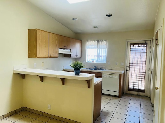 kitchen featuring a kitchen breakfast bar, kitchen peninsula, plenty of natural light, and white dishwasher