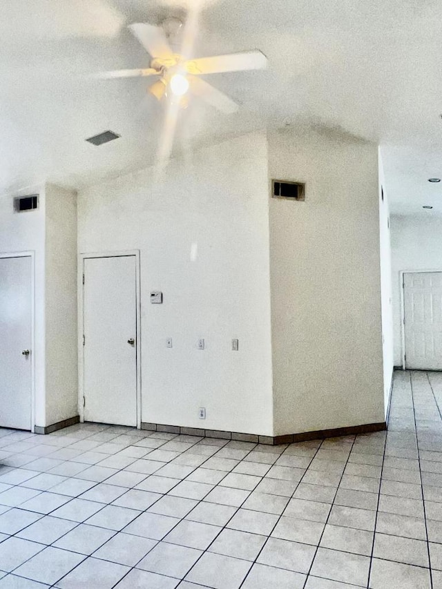 spare room featuring ceiling fan, light tile patterned floors, and a textured ceiling