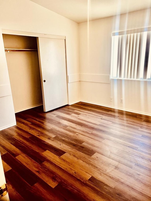 unfurnished bedroom with hardwood / wood-style flooring and a closet