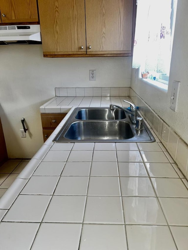 kitchen featuring tile countertops and sink