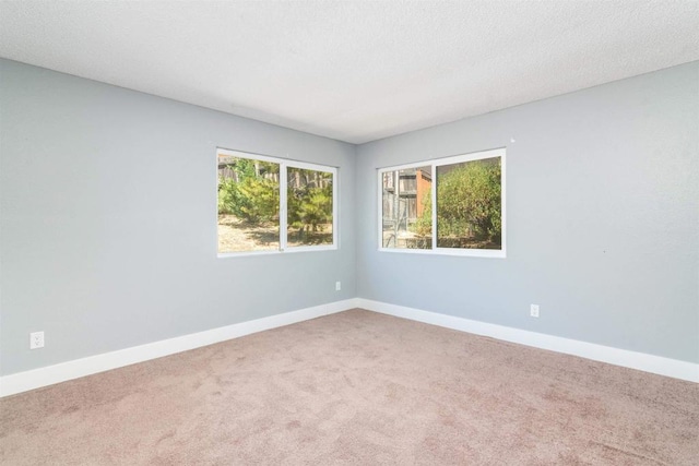 carpeted spare room with a textured ceiling