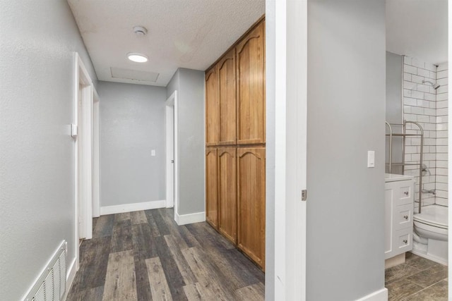 hall featuring dark hardwood / wood-style flooring and a textured ceiling