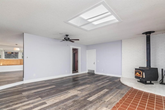 unfurnished living room featuring dark hardwood / wood-style flooring, ceiling fan, a textured ceiling, and a wood stove