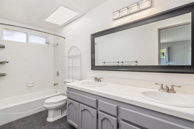 full bathroom featuring vanity, tile patterned flooring, toilet, and tiled shower / bath