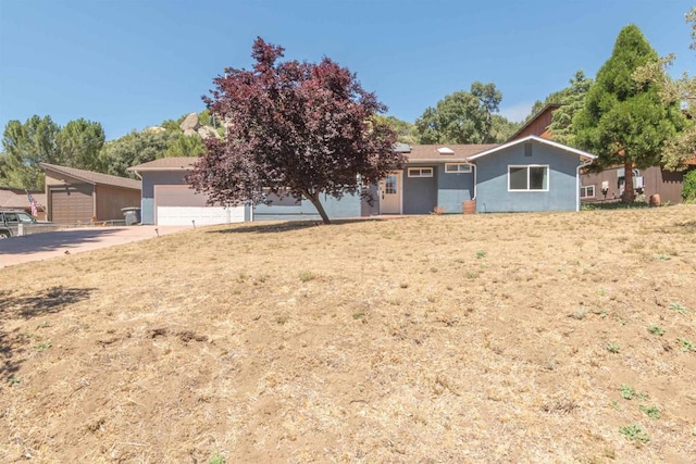 ranch-style house with a garage and a front lawn