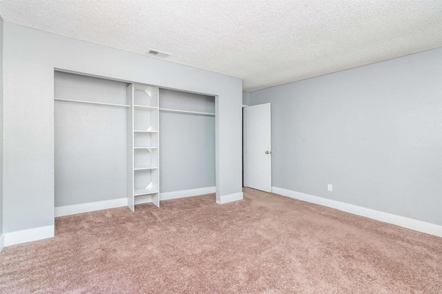 unfurnished bedroom featuring carpet floors, a closet, and a textured ceiling