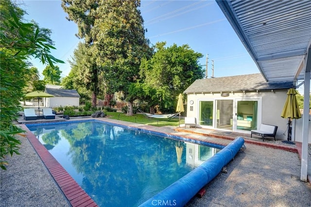 view of swimming pool featuring an outbuilding and a patio area