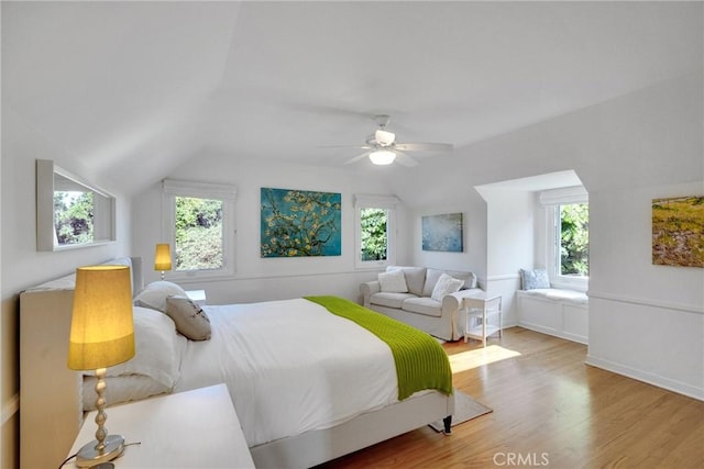 bedroom featuring multiple windows, wood-type flooring, and vaulted ceiling