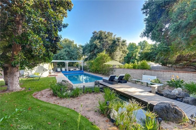 view of pool featuring a wooden deck and a lawn