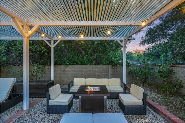 patio terrace at dusk with a pergola and an outdoor living space with a fire pit