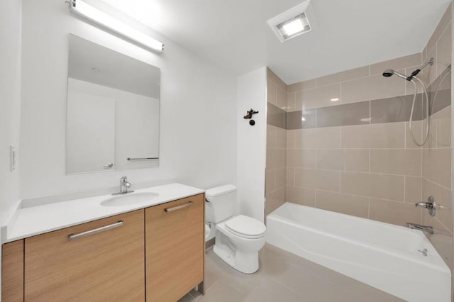 full bathroom with tile patterned floors, vanity, tiled shower / bath combo, and toilet