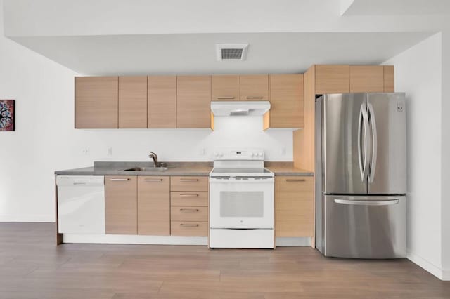 kitchen with light brown cabinets, sink, white appliances, and light hardwood / wood-style flooring