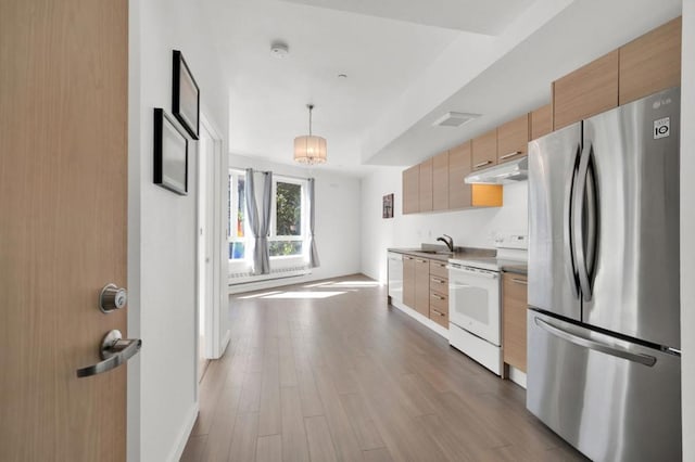 kitchen with white appliances, light brown cabinets, decorative light fixtures, a chandelier, and light hardwood / wood-style floors