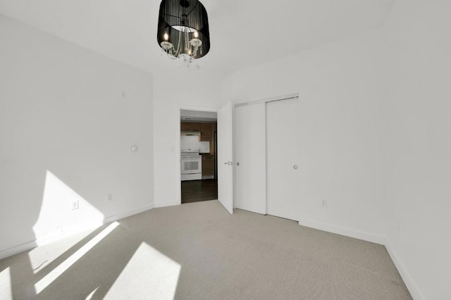 empty room featuring carpet floors and an inviting chandelier