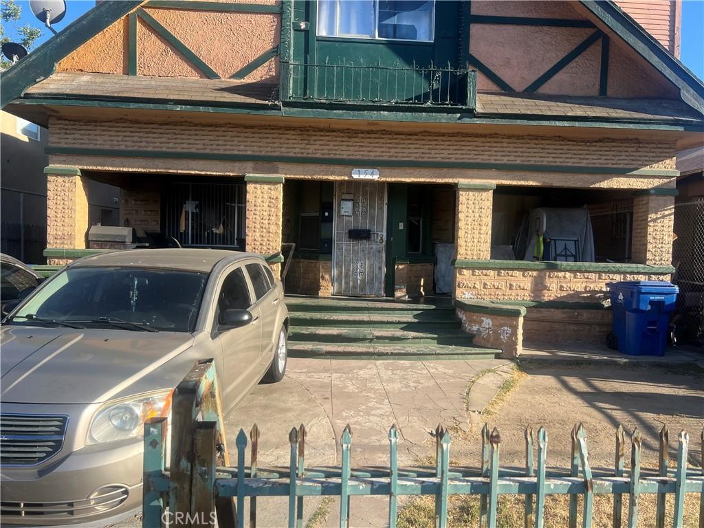 view of front of house featuring brick siding and fence