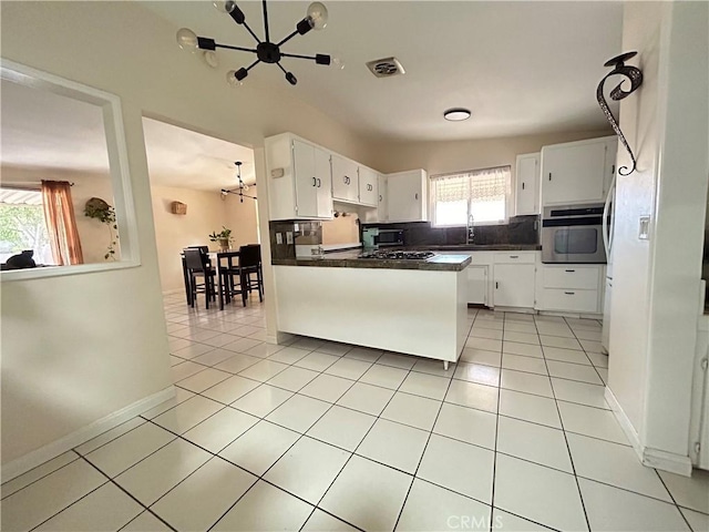 kitchen featuring plenty of natural light, white cabinets, and a notable chandelier