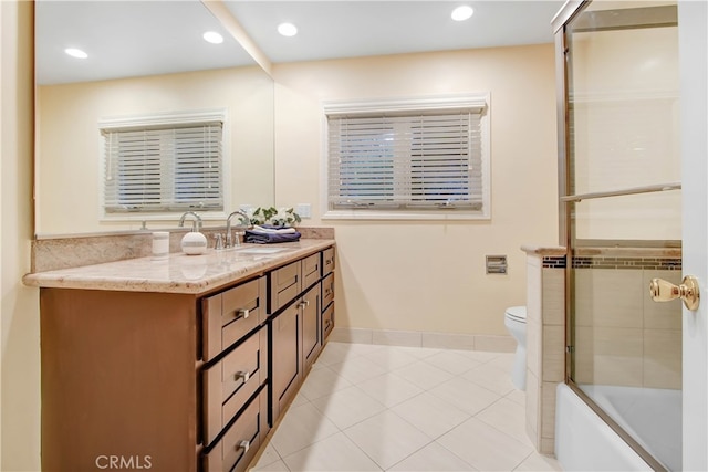 full bathroom featuring tile patterned floors, vanity, toilet, and combined bath / shower with glass door