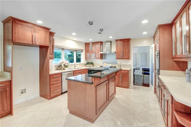 kitchen with a center island, wall chimney exhaust hood, stainless steel dishwasher, dark stone countertops, and decorative light fixtures