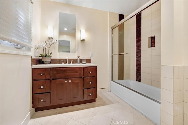 bathroom featuring tile patterned flooring, vanity, and enclosed tub / shower combo