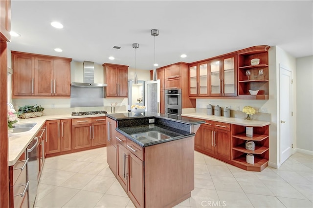 kitchen with stainless steel appliances, wall chimney range hood, a kitchen island, pendant lighting, and light tile patterned floors