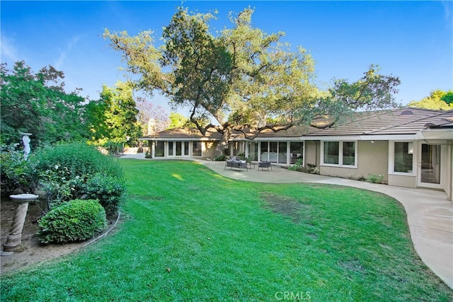 view of yard with a sunroom and a patio