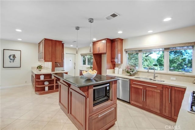 kitchen featuring black microwave, sink, dishwasher, a center island, and hanging light fixtures