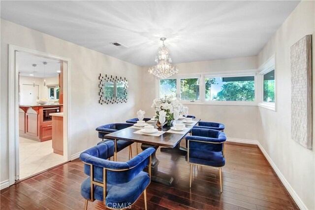 dining space featuring wood-type flooring and a chandelier