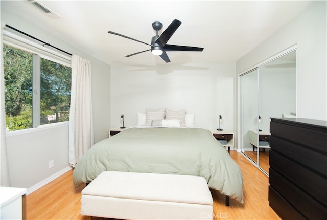 bedroom with light hardwood / wood-style flooring, a closet, and ceiling fan