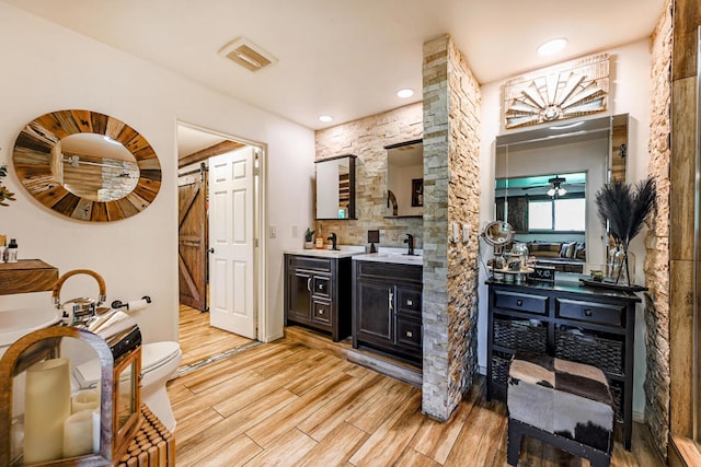 bathroom with wood-type flooring, vanity, and ceiling fan