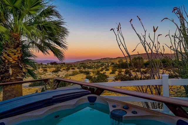 pool at dusk featuring a mountain view