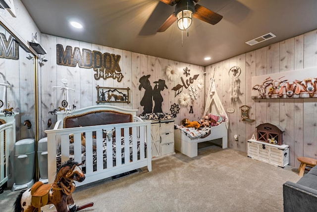 bedroom featuring carpet floors, a nursery area, and ceiling fan