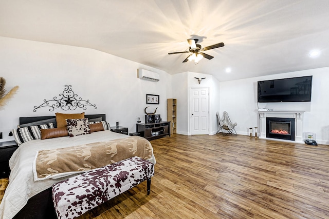 bedroom with wood-type flooring, lofted ceiling, ceiling fan, and a wall mounted air conditioner