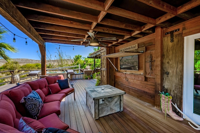 wooden terrace with outdoor lounge area, ceiling fan, and a mountain view