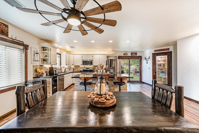 dining room with ceiling fan, light hardwood / wood-style flooring, and sink