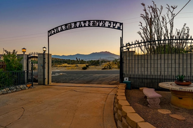 gate at dusk featuring a mountain view