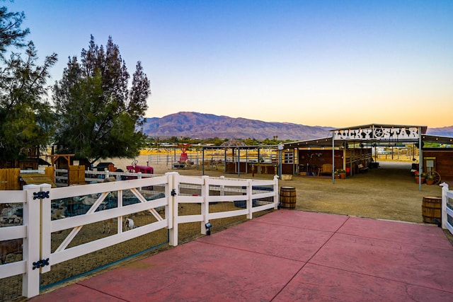 patio terrace at dusk featuring a mountain view