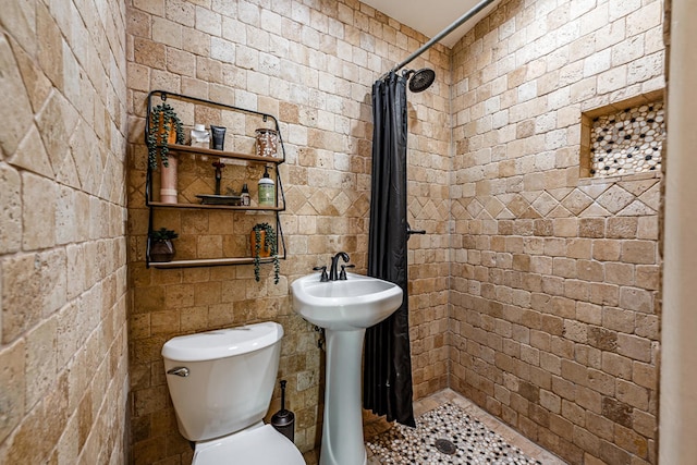 bathroom with walk in shower, sink, and toilet