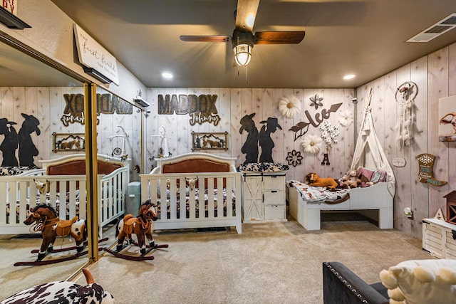 carpeted bedroom with a crib and wooden walls