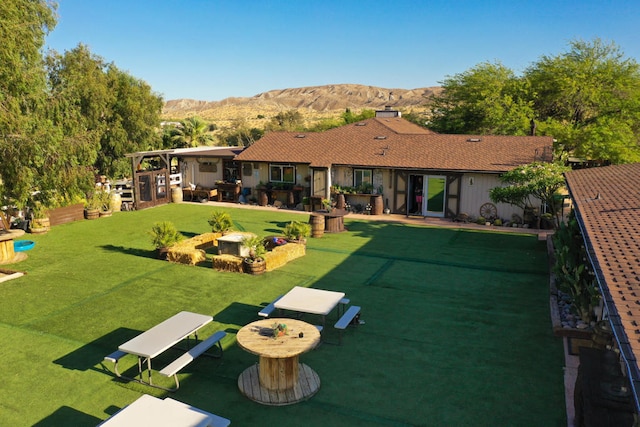 exterior space with a patio, a yard, and a mountain view