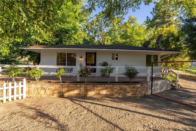 ranch-style house featuring fence and stucco siding